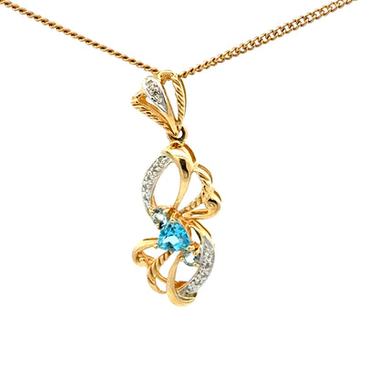 14k yellow gold pendant with a blue topaz