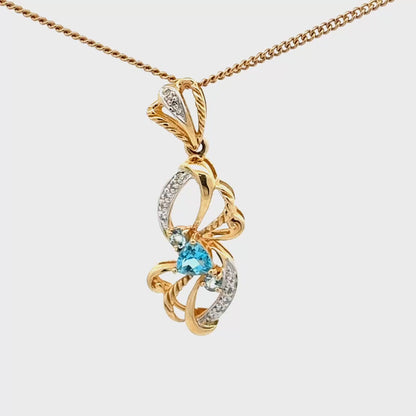 14k yellow gold pendant with a blue topaz