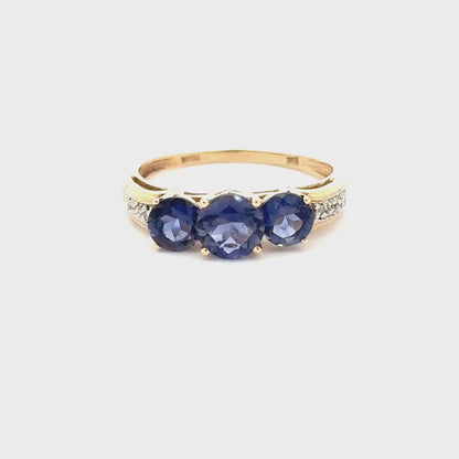10K yellow gold ring with a trio of tanzanites and small diamonds